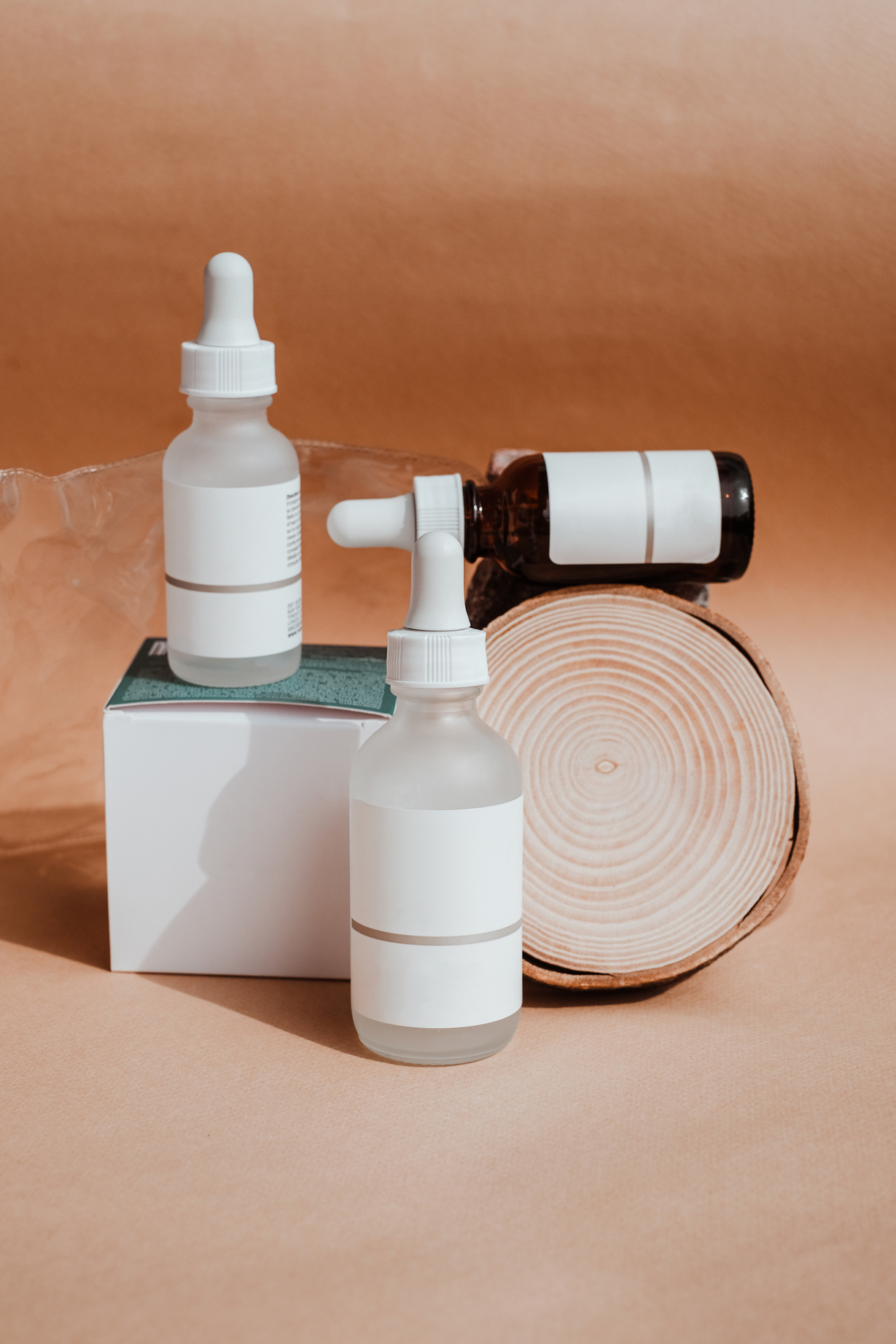two bottles of skincare products sit on top of a wooden log